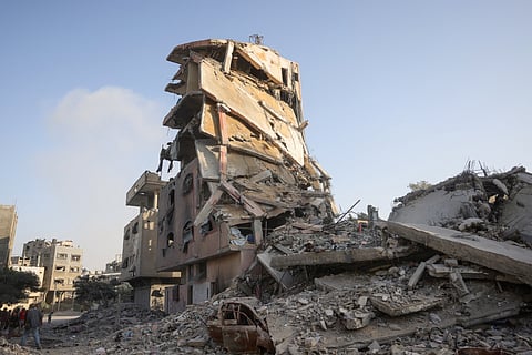 Palestinians gather at the site of Israeli air strikes on a six-storey building in the Saftawi neighbourhood west of Jabalia in the northern Gaza Strip on August 19, 2025.