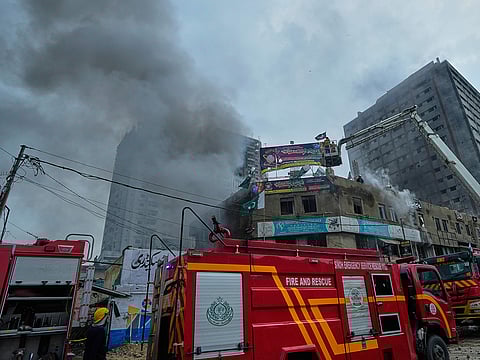 Firefighters try to extinguish a fire following an explosion at a fireworks storage facility, in Karachi, on Thursday, August 21, 2025.
