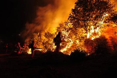 Firefighters battle a wildfire in Spain. While flights from the UAE have not been affected, travel experts say Europe has become a more challenging destination this summer amid heatwaves, visa delays and new border procedures.