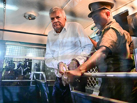 Sri Lanka's former president Ranil Wickremesinghe is escorted to his seat in a prison bus in Colombo on August 22, 2025, after a magistrate ordered him to be held in remand custody till August 26, 2025, following allegations that he misused state funds to travel to Britain in 2023.