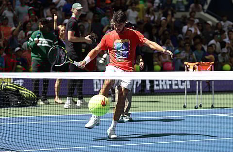 Carlos Alcaraz of Spain kicks a large tennis ball into the crowd during Arthur Ashe Kids' Day at USTA Billie Jean King National Tennis Center on August 23, 2025 in New York City.