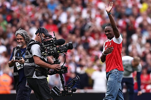 Eberechi Eze waves to the crowd as he is unveiled as a new signing ahead of the English Premier League football match between Arsenal and Leeds United at the Emirates Stadium in London on August 23, 2025.