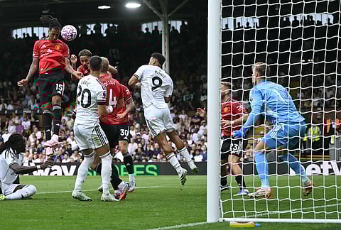 Manchester United's French defender Leny Yoro (L) headers the ball to score the opening goal during the English Premier League football match against Fulham at Craven Cottage in London on August 24, 2025.