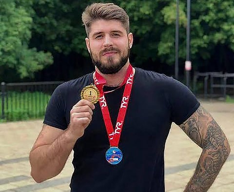 This undated picture released by Turkish news agency DHA (Demiroren News Agency) on August 25, 2025 shows Russian swimmer Nikolai Svechnikov showing his medal from a previous swim race in Istanbul.