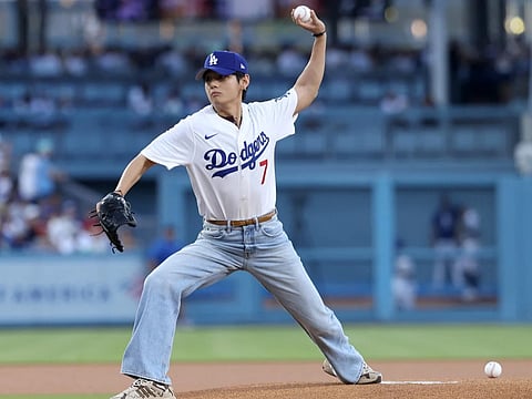 Kim Tae-Hyung, aka V of BTS, throws out the first pitch prior to the game between the Los Angeles Dodgers and the Cincinnati Reds at Dodger Stadium on August 25, 2025 in Los Angeles, California.