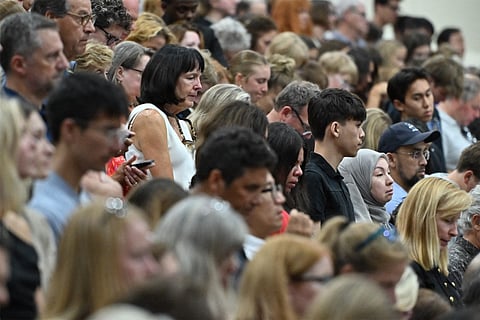People attend at a vigil at Academy of Holy Angels in Richfield, Minnesota, for the victims of a mass shooting at Annunciation Catholic Church and School in Minneapolis.