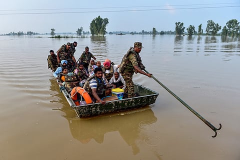 Indian Army personnel rescue local residents using a boat to evacuate through the flooded waters of the Beas river at Baoopur village in the Kapurthala district of India's Punjab state on August 28, 2025.