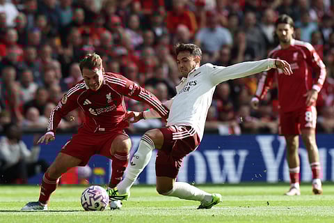 Liverpool's Argentinian midfielder 10 Alexis Mac Allister (L) and Arsenal's Spanish defender Martin Zubimendi (C) battles for the ball during the English Premier League football match at Anfield in Liverpool, north west England on August 31, 2025.