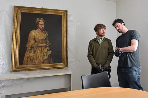 Visual arts teacher Ariel Bassano (L) stands next to a painting identified by Dutch newspaper AD as believed to be "Portrait of a Lady" by Italian baroque portraitist Giuseppe Ghislandi (1655–1743), allegedly stolen by the Nazis from a Dutch Jewish art collector, as it is displayed at the Public Prosecutor's Office in Mar del Plata, Argentina, on September 3, 2025.