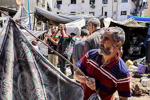 People inspect damages at a tent encampment that was sheltering displaced people, after it was hit by Israeli bombardment, near Shifa Hospital in Gaza City. File photo taken on September 4, 2025.