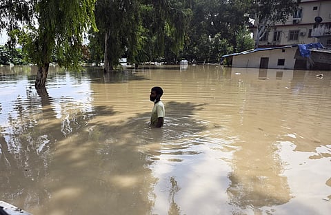 A man wades through water following the rise in water level of the Yamuna river, near ISBT in New Delhi on September 3, 2025.