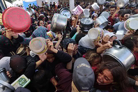 Palestinians shove to receive a meal from a charity kitchen in the Nuseirat refugee camp in the Israel-besieged Gaza Strip on September 4, 2025, where the UN has declared famine after nearly two years of war.