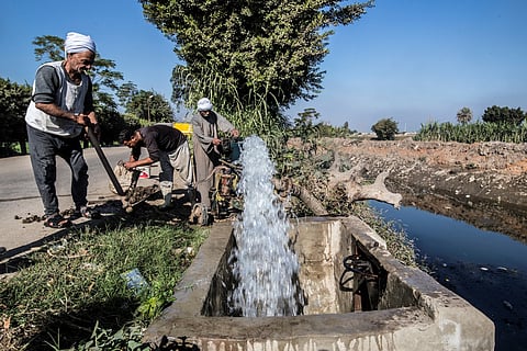 Egyptian farmer Mohamed Omar (L), 65, supplies his farmland with water from a canal, fed by the Nile river, in the village of Baharmis on the outskirts of Egypt's Giza province, northwest of the capital Cairo, on December 1, 2019.