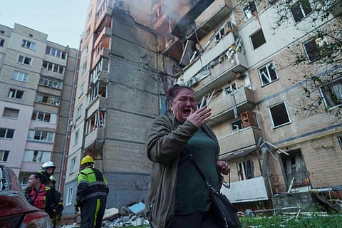 A woman reacts in front of a residential building heavily damaged by a Russian strike in Kyiv, Ukraine.