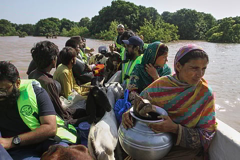 Volunteers evacuate villagers from a flooded area following heavy rains and raising water in rivers, in Muzaffargarh, Pakistan.