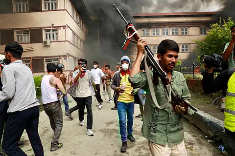 A protester carries a firearm as demonstrators gather outside Nepal's Supreme Court during a protest.