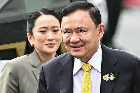 Thailand's former Prime Minister Thaksin Shinawatra arrives with his daughter Thailand's sacked prime minister Paetongtarn Shinawatra (L) at the Supreme Court in Bangkok.