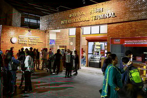 Passengers gather at an entrance of Tribhuvan International Airport after it reopened in Kathmandu on September 10, 2025, following a closure due to civil unrest in Nepal's capital.