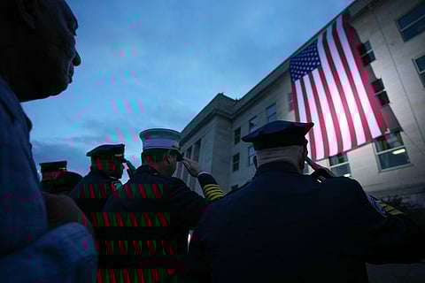 Members of the military and first responders watch as an American flag is unfurled on the side of the Pentagon to commemorate the 24th anniversary of the 9/11 terror attacks on September 11, 2025 in Arlington, Virginia.