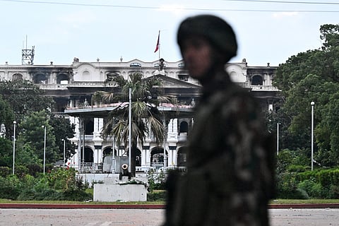 Army personnel stands guard near Singha Durbar, the main administrative building for the Nepal government, after it was set ablaze by protesters, in Kathmandu on September 12, 2025.