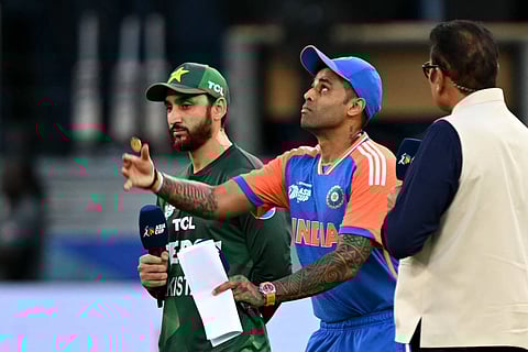 India's captain Suryakumar Yadav (C) tosses the coin at the start of the Asia Cup 2025 Twenty20 international cricket match between India and Pakistan at the Dubai International Stadium in Dubai on September 14, 2025.