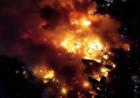 The blaze, which started around 8:28pm on Saturday in Buildings 7 and 8 of "Happyland" rapidly spread through dozens of shanty homes built from highly flammable light materials like plywood and corrugated metal.