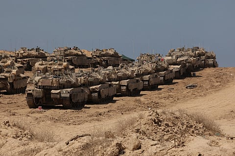 This picture taken from a position at Israel's border with the Gaza Strip shows Israeli troops deployed near the border fence with the besieged Palestinian territory on September 17, 2025.