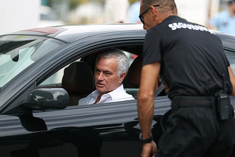 Former Fenerbahce's Portuguese coach Jose Mourinho talks with a security staff member as he arrives for a meeting with Benfica President at Benfica Campus training center in Seixal, outskirts of Lisbon, on September 18, 2025.