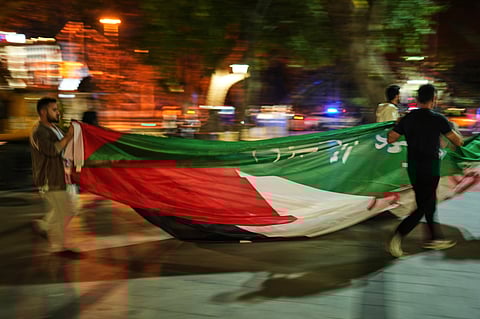 People carry a Palestinian flag as they gather for a rally in support of Hamas, in Istanbul, Turkey, on September 20, 2025.