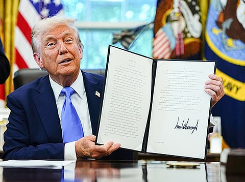 US President Donald Trump holds a signed executive order authorising the Trump Gold Card in the Oval Office of the White House in Washington, DC, US, on Friday, September 19, 2025.