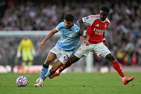 Manchester City's Portuguese midfielder Matheus Nunes (left) vies with Arsenal's English midfielder Bukayo Saka during the English Premier League football match at the Emirates Stadium in London on September 21, 2025.