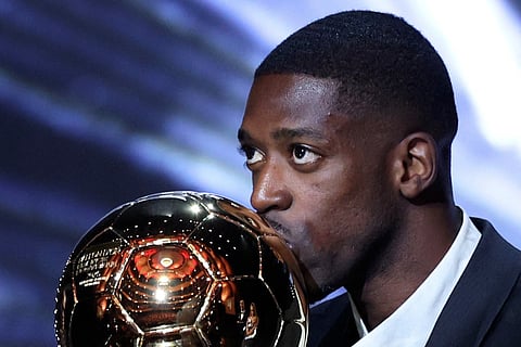 Paris Saint-Germain's French forward Ousmane Dembele kisses the Ballon d'Or award during the 2025 Ballon d'Or France Football award ceremony at the Theatre du Chatelet in Paris on September 22, 2025.