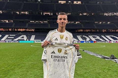 Moroccon earthquake survivor Abderrahim Ouhida holding Real Madrid jersey at the Bernabeu