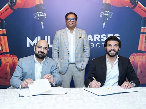 Adnan Ul Mulk, Chairman of Mulk Marses Robotics, flanked by while Shaji Ul Mulk, Chairman of Mulk International, signing the agreement to create the new joint venture that will see the development of a number of robotic construction industries in the UAE, EU and USA.