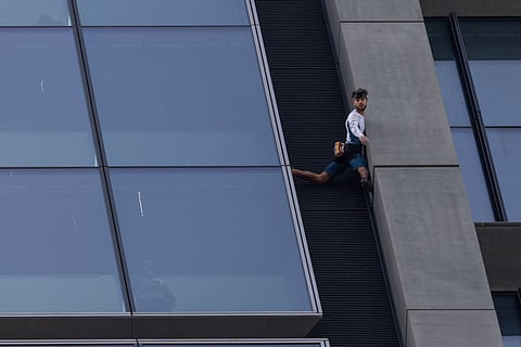 French urban climber Titouan Leduc is seen as he free climbs one of Europe's tallest skyscrapers, the Varso Tower in Warsaw, Poland.