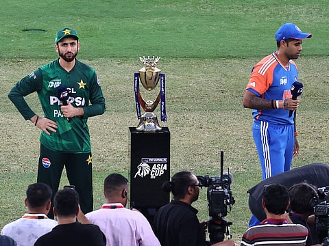 India's captain Suryakumar Yadav (R) and his Pakistani counterpart Salman Agha stand on the field after the toss before the start of the Asia Cup 2025 Twenty20 international cricket final match between India and Pakistan at the Dubai International Stadium in Dubai.
