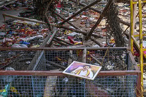 A portrait of actor-turned-politician Vijay is seen near the scattered shoes after a stampede that broke out Saturday evening during his political rally in the Karur district, in the Indian state of Tamil Nadu, on September 28, 2025.
