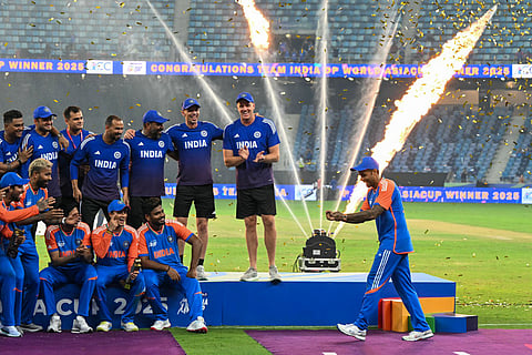 India's captain Suryakumar Yadav playfully pretends to hold the trophy as his team celebrates their victory in the Asia Cup 2025 at the Dubai International Stadium in Dubai on September 28, 2025.