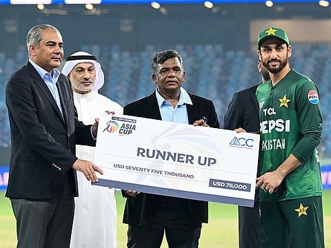 Pakistan's captain Salman Ali Agha (R) receives the runner up cheque from Asian Cricket Council (ACC) and Pakistan Cricket Board (PCB) chairman Mohsin Naqvi during the presentation ceremony at the end of the Asia Cup 2025 T20 final match against India at the Dubai International Stadium on September 28, 2025.