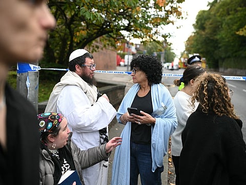 Members of the local Jewish community wait at a police cordon near Heaton Park Hebrew Congregation synagogue in Crumpsall, north Manchester, on October 2, 2025, following an attack at the synagogue.