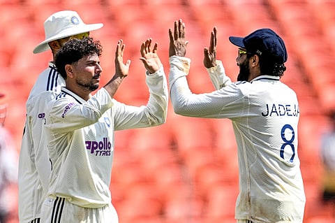India's Kuldeep Yadav (L) celebrates after taking the wicket of West Indies' Roston Chase during the third day of the first Test cricket match between India and West Indies at the Narendra Modi Stadium in Ahmedabad on October 4, 2025.