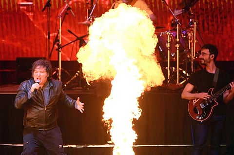 Argentina's President Javier Milei (L) sings during the launch of his new book, "The Making of the Miracle," at the Movistar Arena in Buenos Aires.