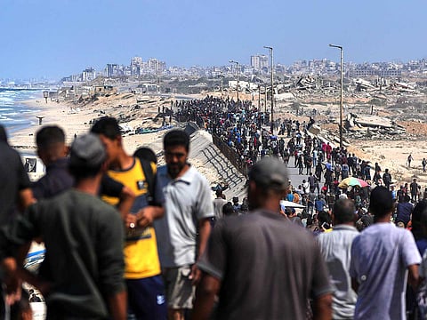 Displaced Palestinians walk along the coastal road near Wadi Gaza in the central Gaza Strip, moving toward northern Gaza, Friday, Oct. 10, 2025, after Israel and Hamas have agreed to a pause in their war and the release of the remaining hostages.