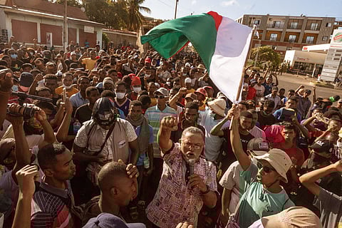 A protester waves a Madagascar flag as they march during a protest calling for constitutional reforms and the resignation of President Andry Rajoelina in Antsiranana on October 10, 2025.