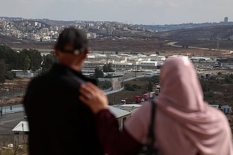 Relatives of a Palestinian prisoner stare at the Ofer military prison complex, located between Ramallah and Beitunia in the occupied West Bank, on October 12, 2025, ahead of an exchange of Israeli hostages and Palestinian prisoners.