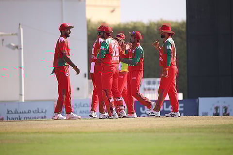 Oman players celebrate a UAE wicket.