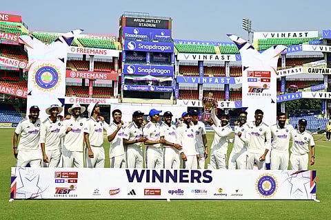 India's players celebrate with the trophy after their win against West Indies' at the end of the fifth day of the second and last Test cricket match between India and West Indies at the Arun Jaitley Stadium in New Delhi on October 14, 2025.