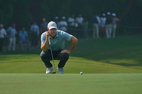 Rory McIlroy of Northern Ireland checks before taking a shot during the DP World Tour Championship golf tournament in New Delhi, India, Thursday, Oct. 16, 2025..