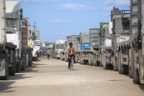 Truck carrying aid provided by the World Food Programme (WFP) wait at the Kissufim crossing, located east of Deir El Balah in the central Gaza Strip, before entering the Palestinian enclave on October 17, 2025.
