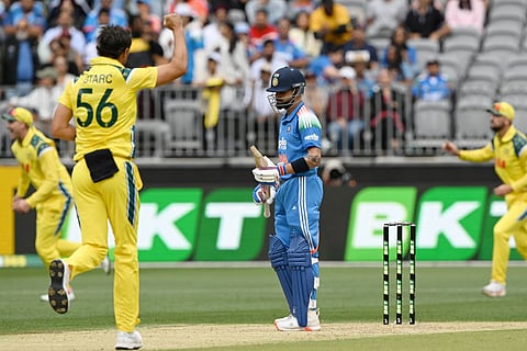 India's Virat Kohli (C) reacts as Australia’s paceman Mitchell Starc (front L) celebrates his wicket during the first one-day international cricket match between Australia and India in Perth on October 19, 2025.